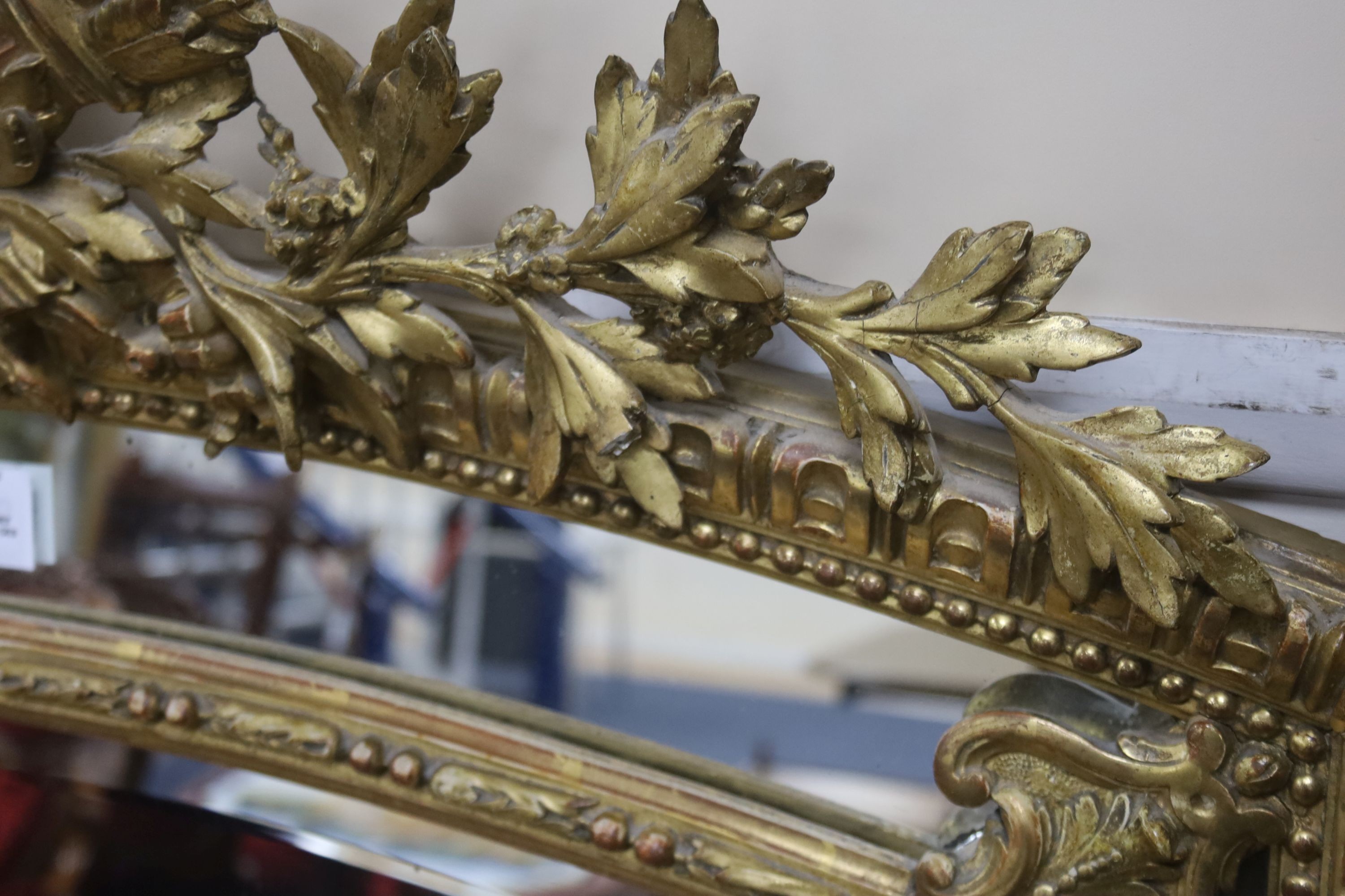 A 19th century giltwood and gesso overmantel mirror with Olympic Torch & Laurel Crown, side cushions with decorated bead detail, width 92cm, height 153cm